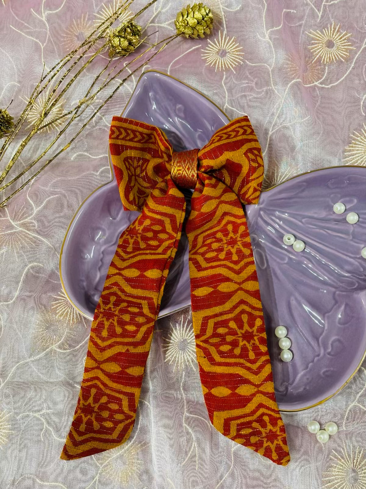 Orange patterned bow with tail