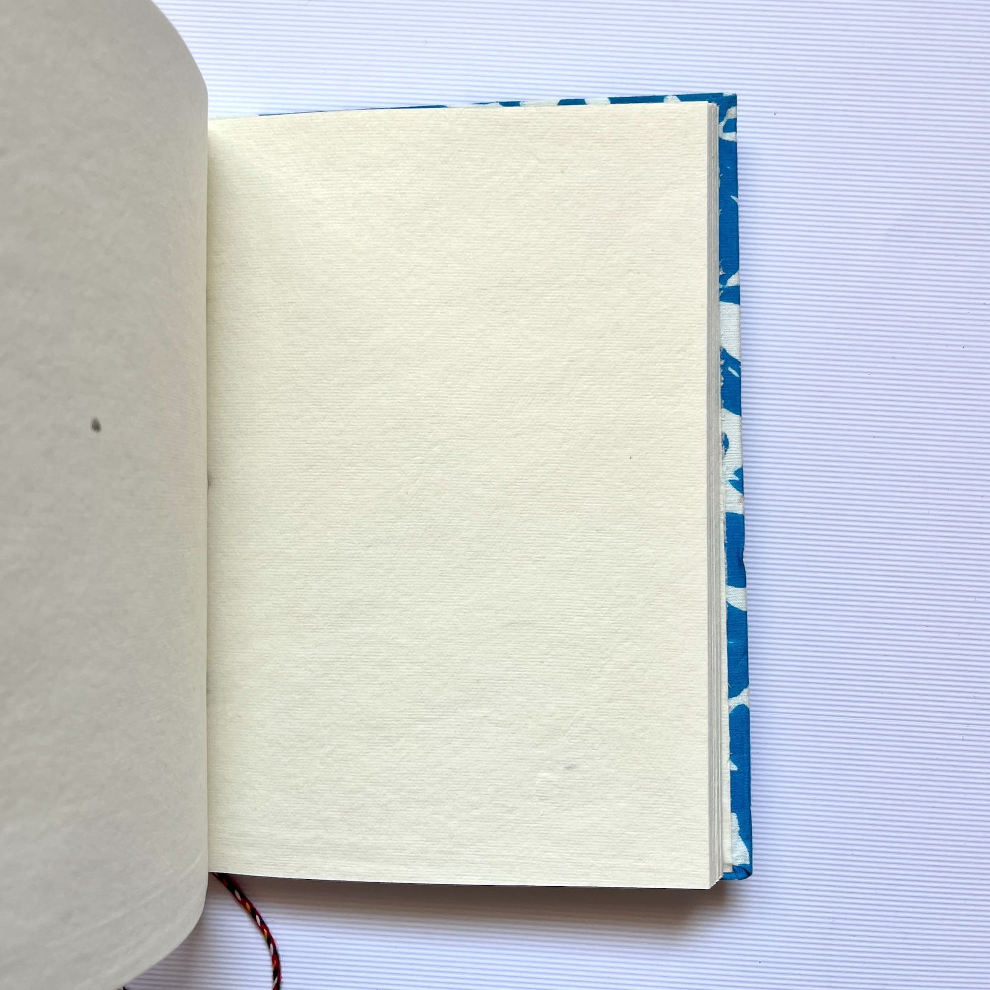 Bold Floral Blue Diary opened to show handmade paper pages