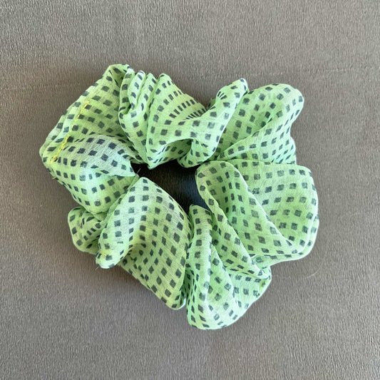 A mint green scrunchie with a fine black checkered pattern for a fresh, playful vibe